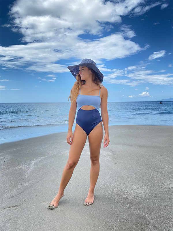 A woman standing on a beach in a bikini.