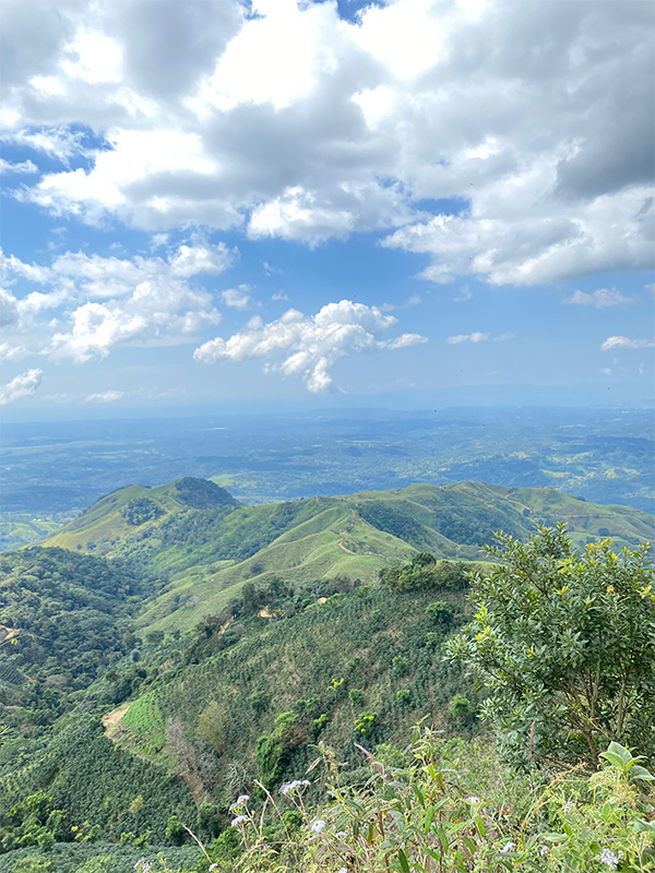 A scenic view of a mountain range with clouds in the sky.
