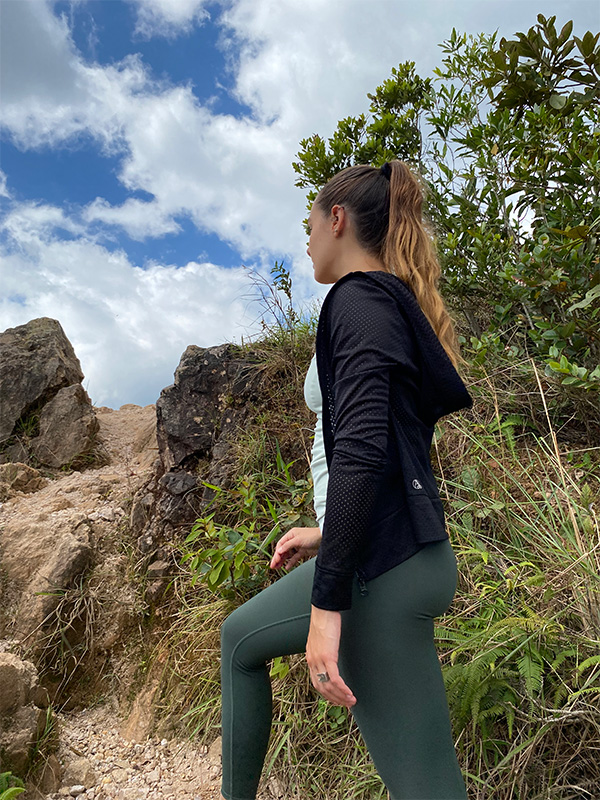 A woman in a black top and green leggings