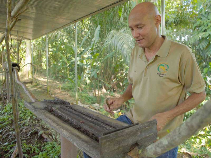 A man standing next to a wooden box.