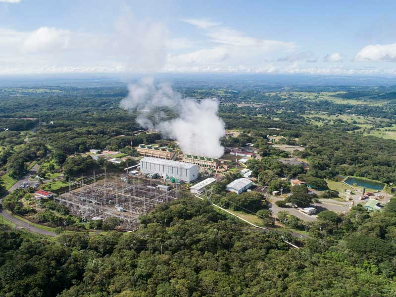 An aerial view of a factory with smoke coming out of it.