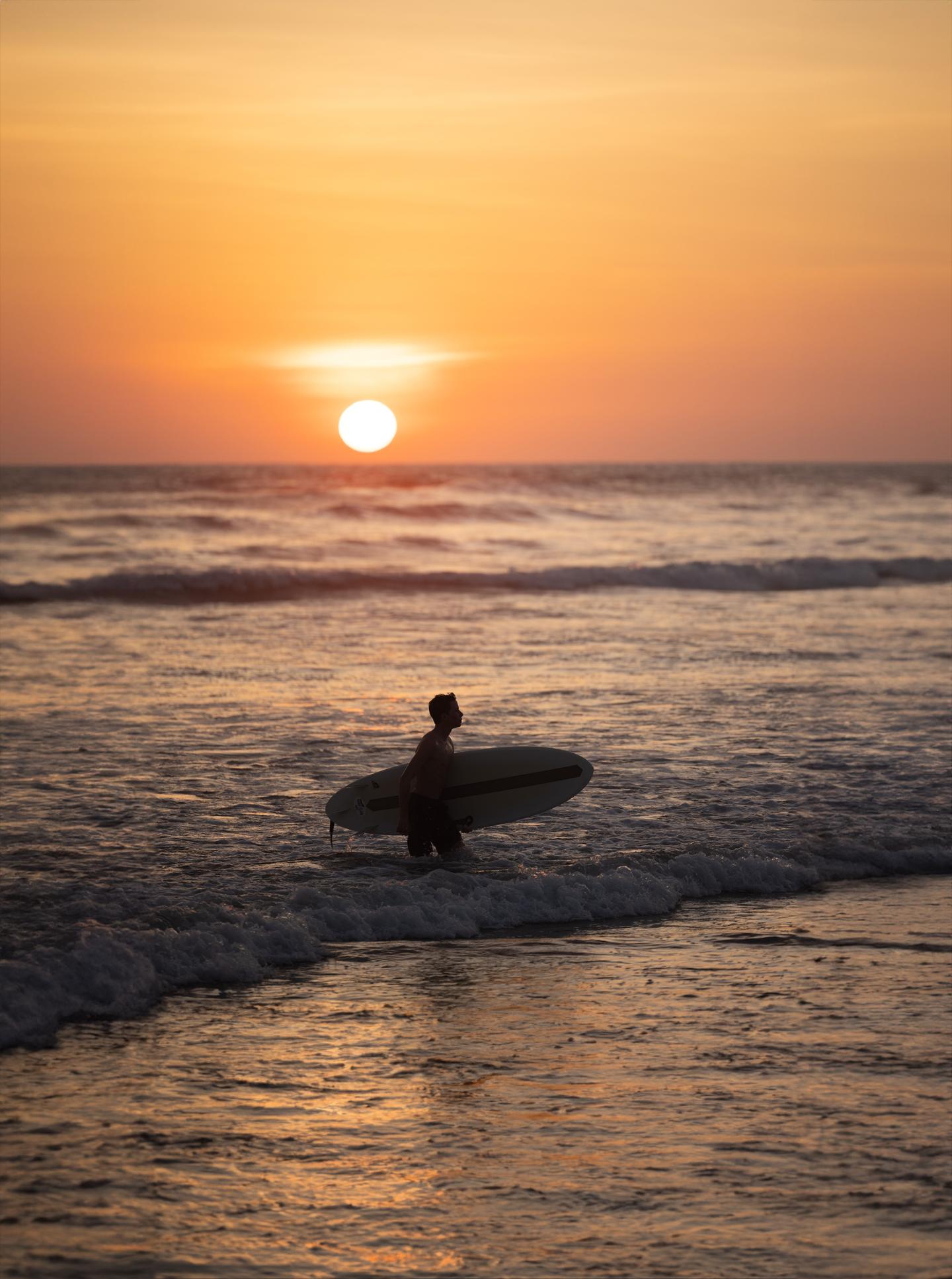 man surfing sunrise ocean guiones